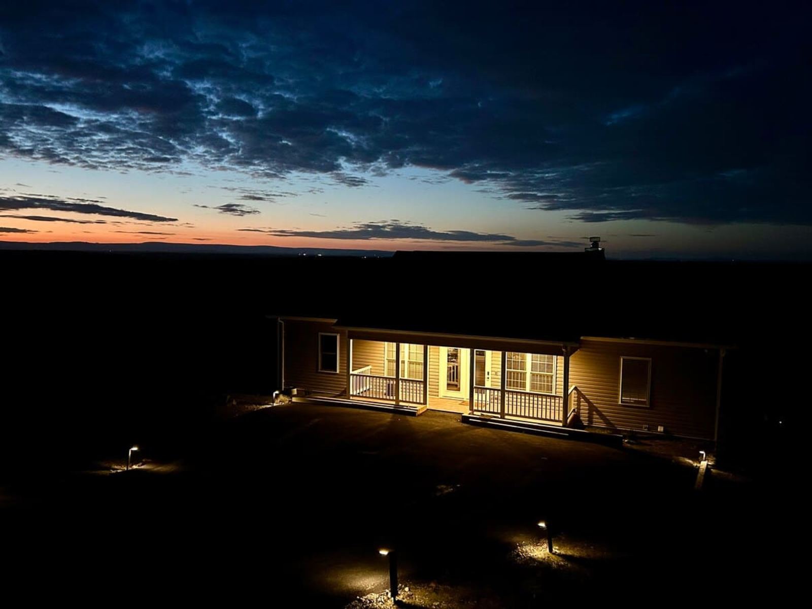 Aerial view at sunset of the house and the long mountain driveway