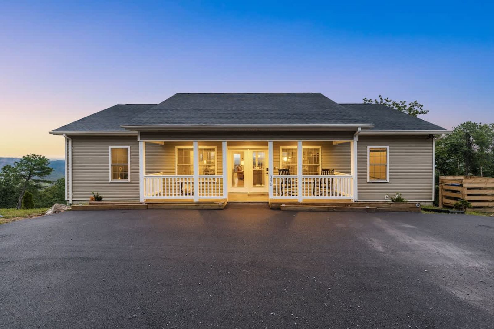 Front of the house at dusk with the covered porch lit