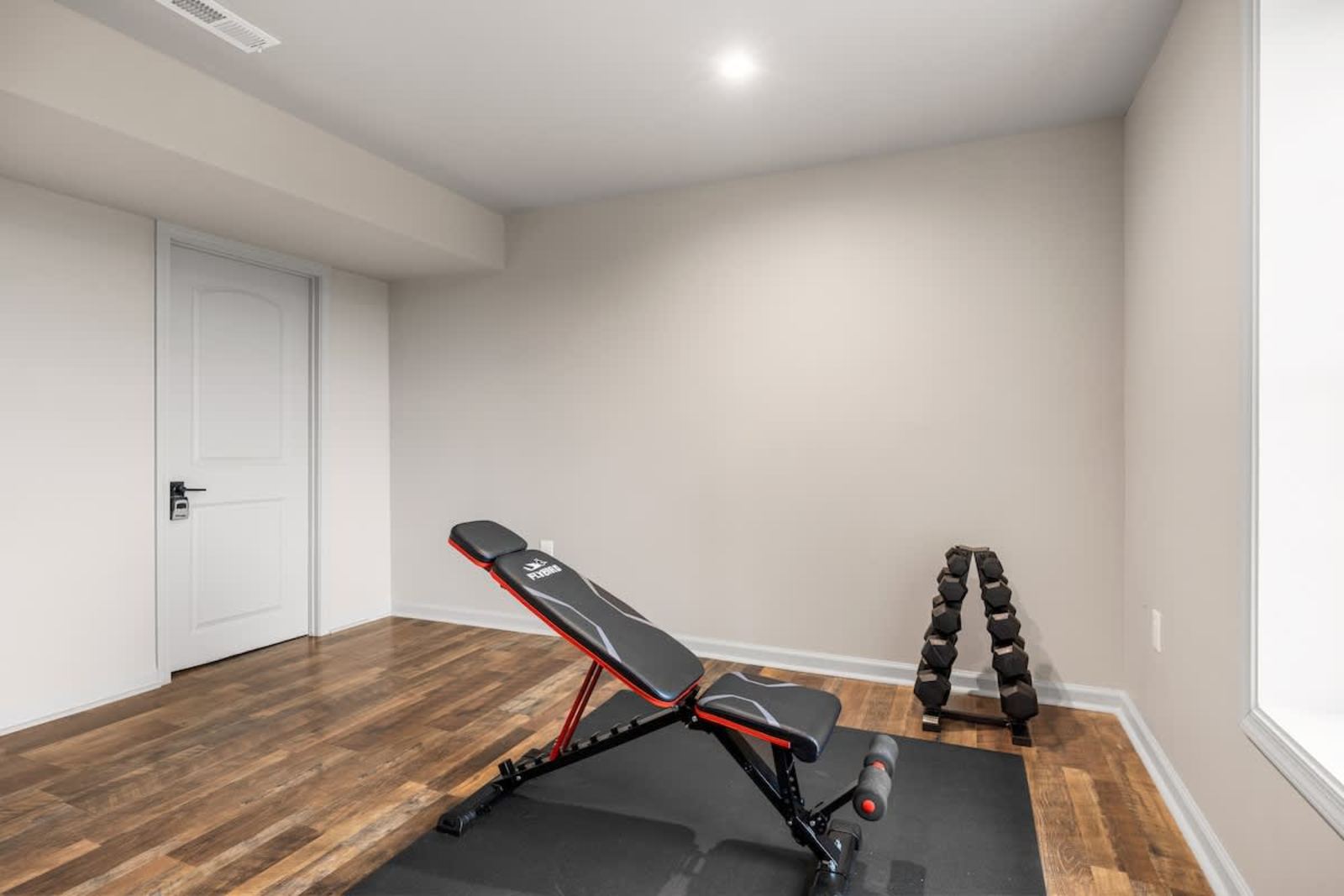 Private home gym with an adjustable bench and dumbbells