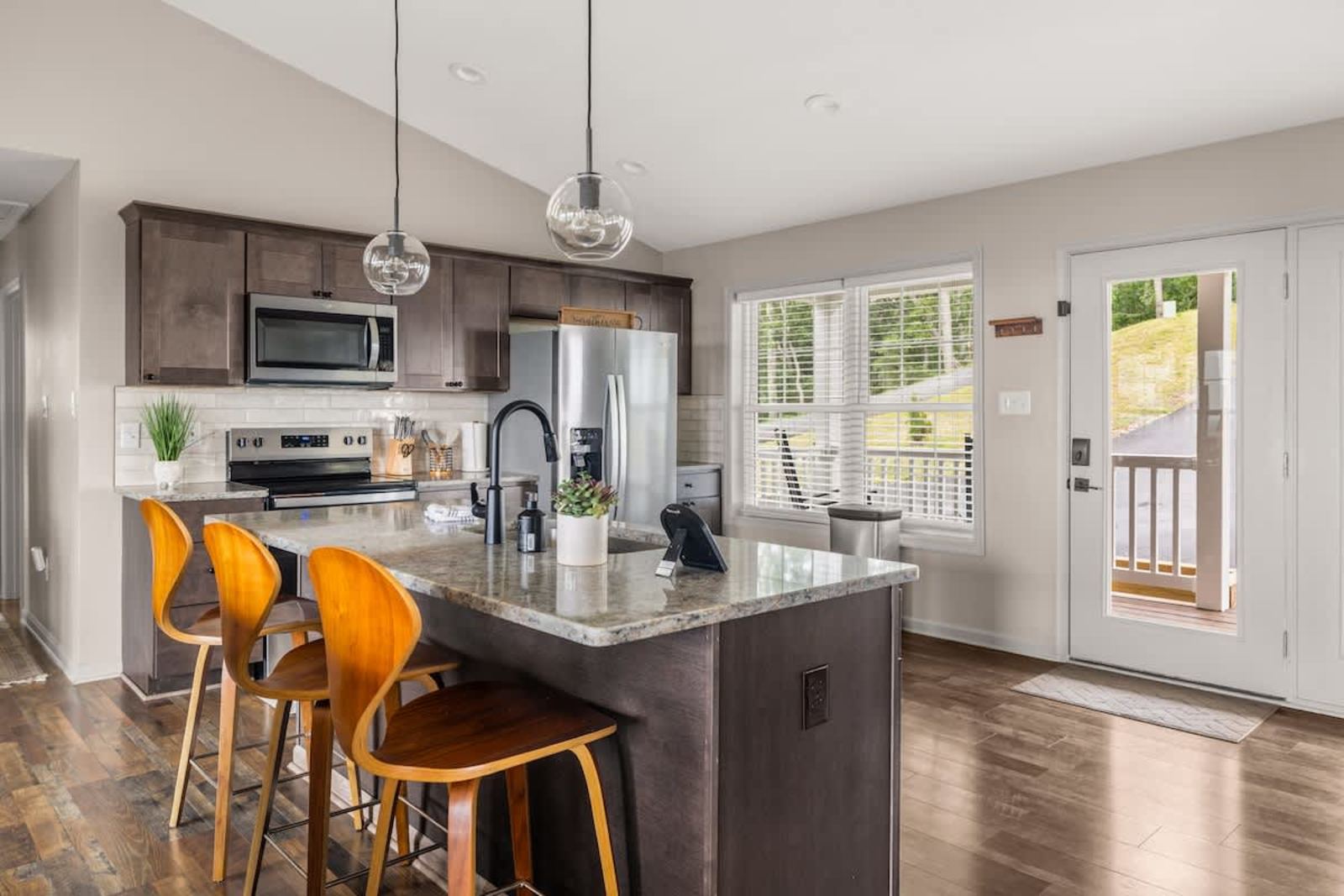 Bright kitchen with an island, stainless appliances, and seating for four